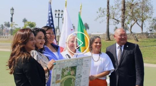 Group photo of Councilmember Eunisses Hernandez holding site map of Reconnecting MacArthur Park project