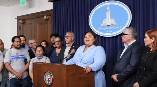 Councilmember Henandez at podium in City Hall Media Room surrounded by Central American Leaders