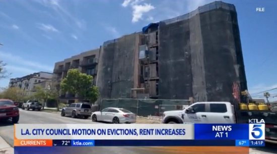 A grey building with cars driving by