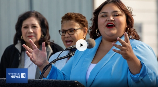 Councilmember Hernandez in a powder blue suit with Mayor Bass behind her