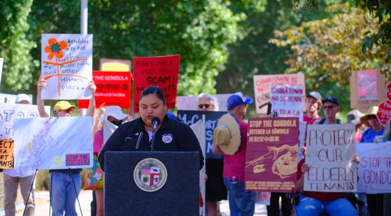 Councilmember Hernandez stands at a podium at a Stop The Gondola rally