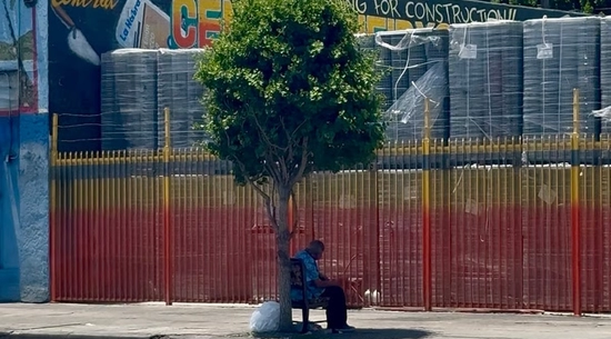 Elder man seeking shade under one of few trees on Central Avenue in South Los Angeles Credit: Ashley Orona